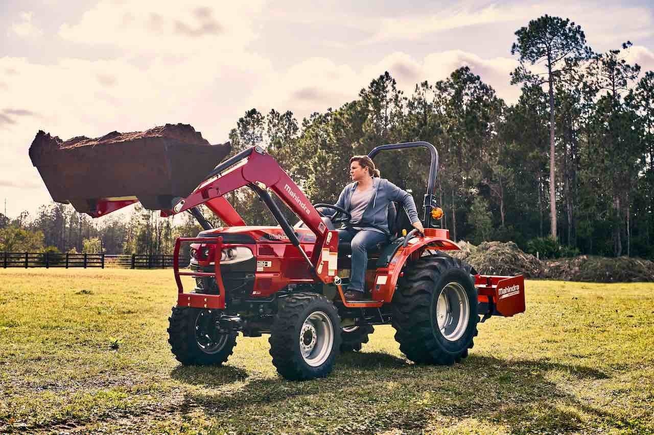 Mahindra tractor pulling a box blade across a field