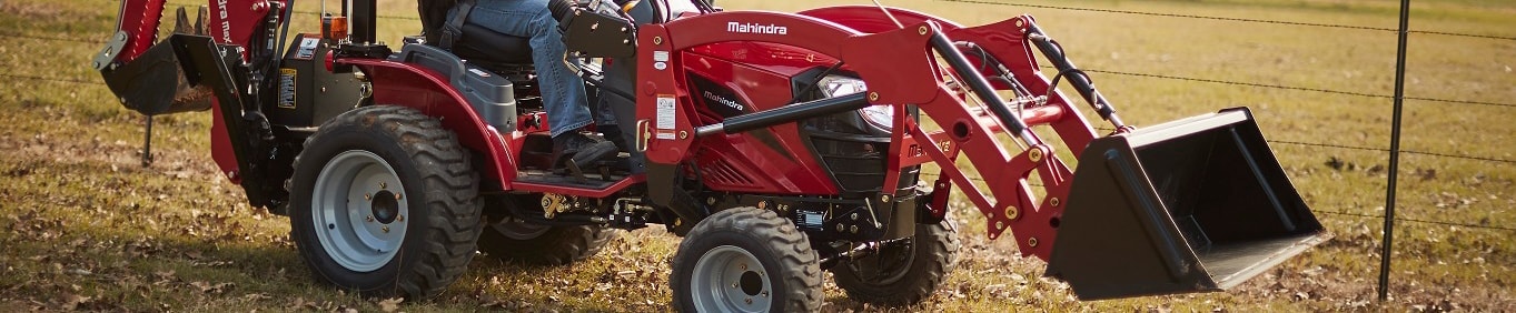 Mahindra tractor with a loader and backhoe working in a field